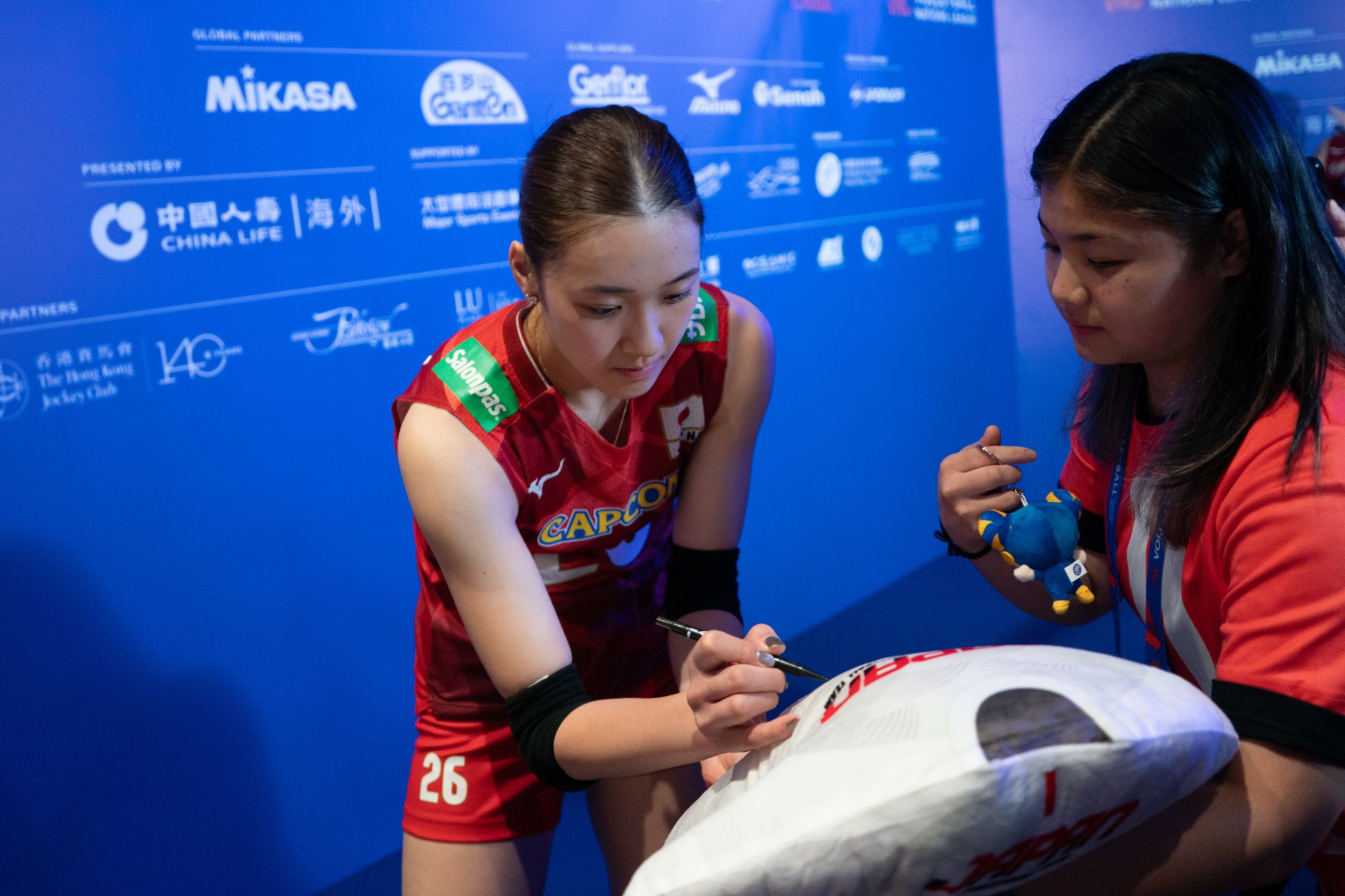 Team Japan player Yoshino Sato (number 26) signing a gift for fans.
