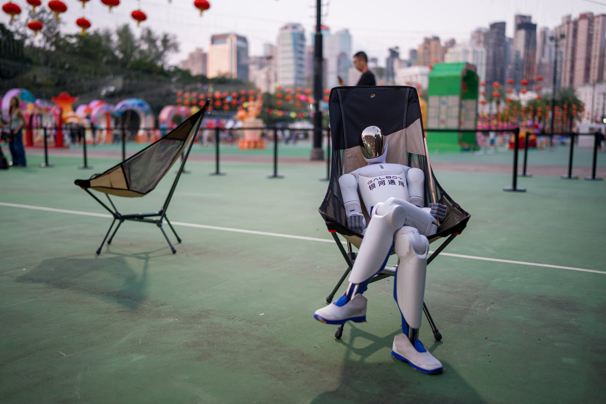 A robot sitting on a chair in Victoria Park.