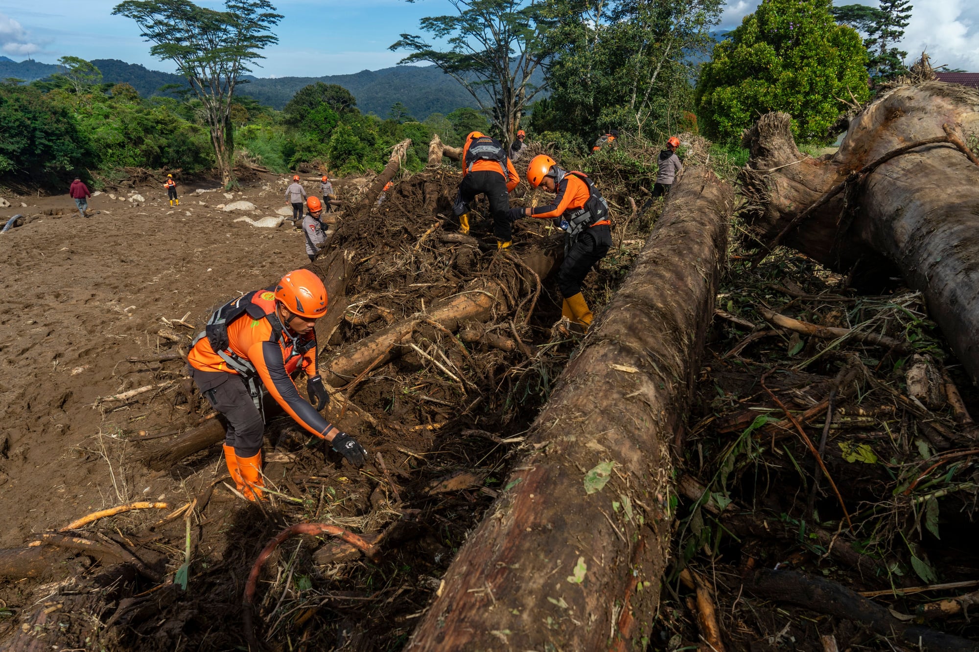 Members of a joint search and rescue team comb an area affected by flash flooding