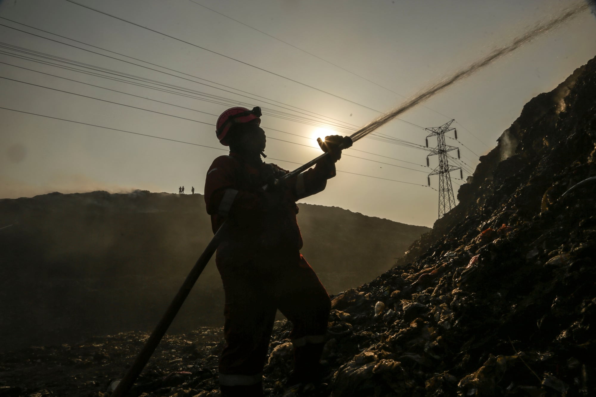 Firefighters work to extinguish flames at the Putri Cempo landfill.