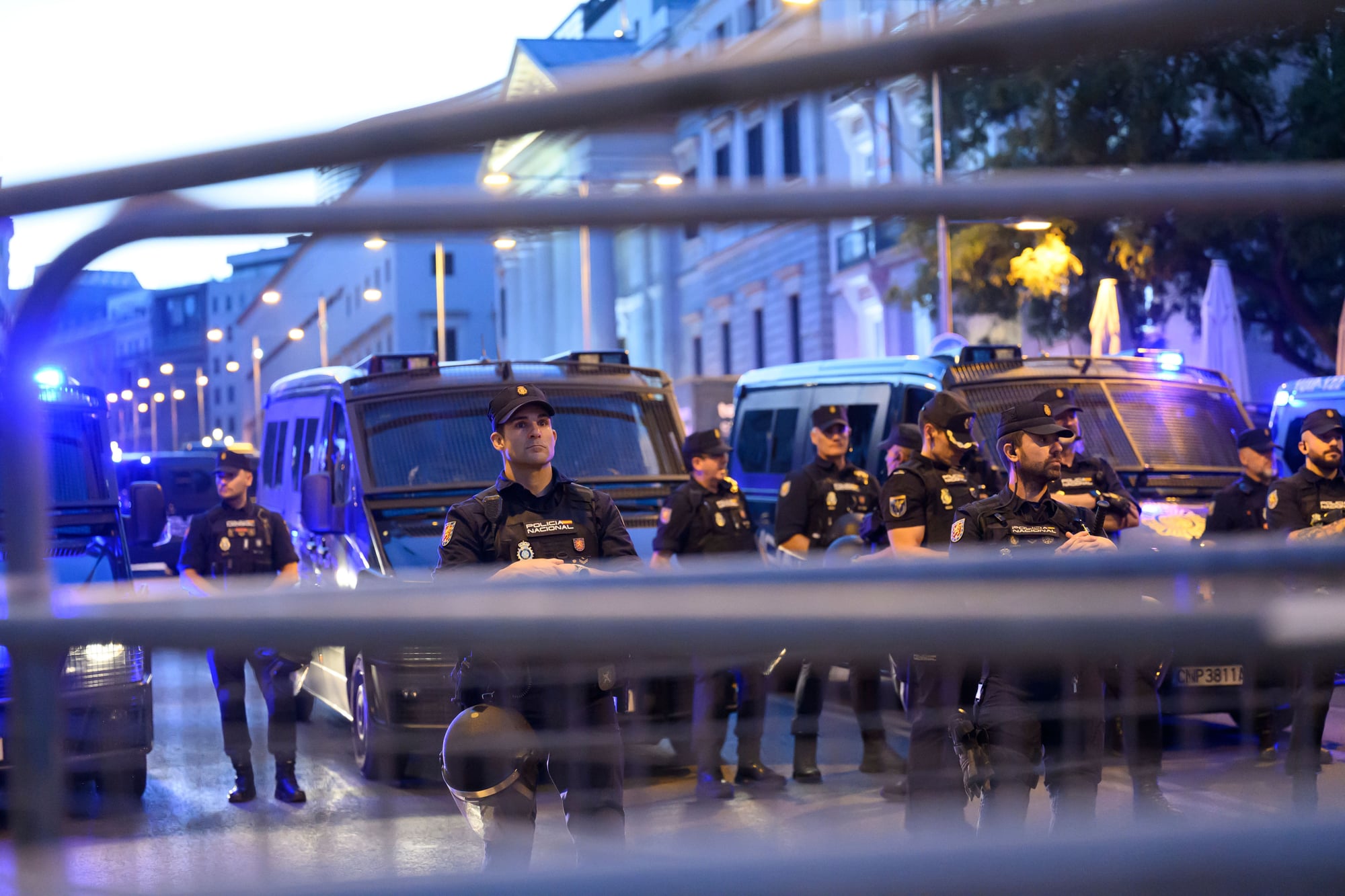 Police officers behind barricades during a protest against evictions