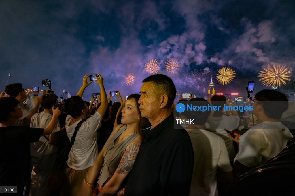 Crowds of citizens and tourists pack the waterfront promenade outside the Hong Kong Cultural Centre in Tsim Sha Tsui, holding up their smartphones to film and photograph the fireworks display illuminating Victoria Harbour during the 77th National Day celebrations on October 1, 2026 in Hong Kong. (Photo by Gordon Choi/TMHK via Nexpher Images)