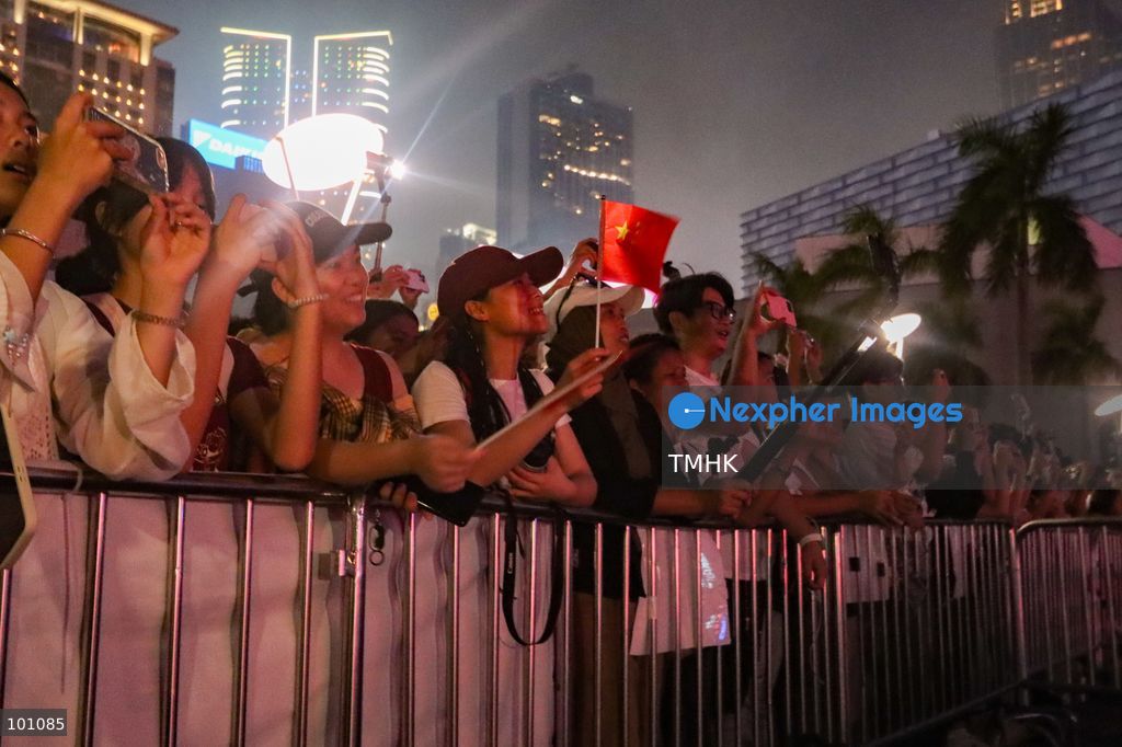 Crowds of citizens and tourists pack the waterfront promenade outside the Hong Kong Cultural Centre in Tsim Sha Tsui, holding up their smartphones to film and photograph the fireworks display illuminating Victoria Harbour during the 77th National Day celebrations on October 1, 2026 in Hong Kong. (Photo by Gordon Choi/TMHK via Nexpher Images)