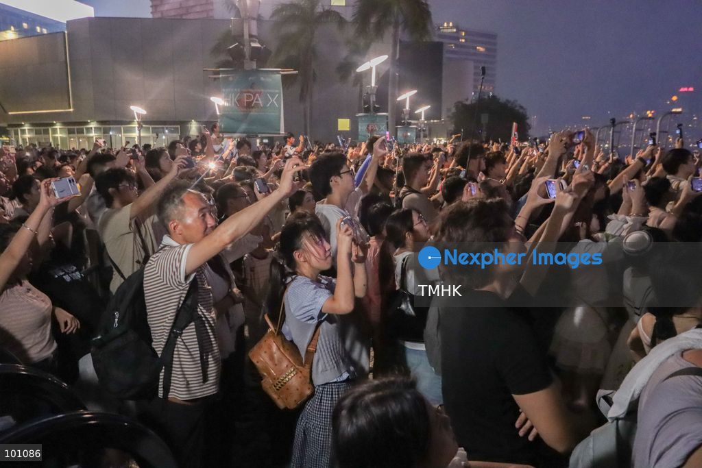 Crowds of citizens and tourists pack the waterfront promenade outside the Hong Kong Cultural Centre in Tsim Sha Tsui, holding up their smartphones to film and photograph the fireworks display illuminating Victoria Harbour during the 77th National Day celebrations on October 1, 2026 in Hong Kong. (Photo by Gordon Choi/TMHK via Nexpher Images)