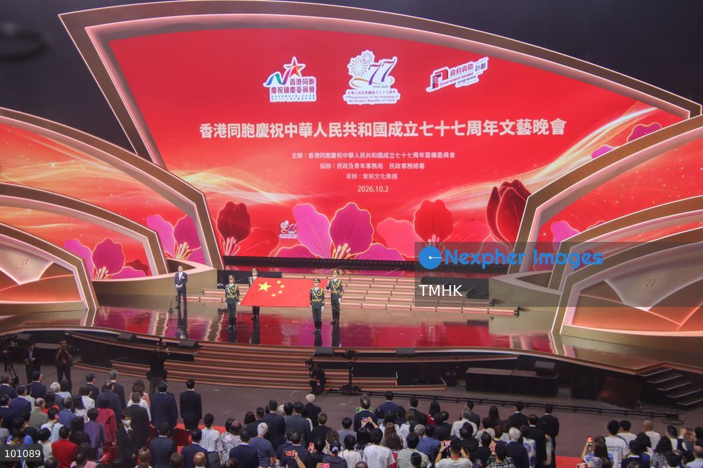 Four members of the guard of honour of the Chinese People's Liberation Army (PLA) Hong Kong Garrison unfurl the national flag of the People's Republic of China on stage as the national anthem plays during the opening of the variety show celebrating the 77th National Day at the Hong Kong Coliseum in Hung Hom on October 2, 2026 in Hong Kong. (Photo by Gordon Choi/TMHK via Nexpher Images)