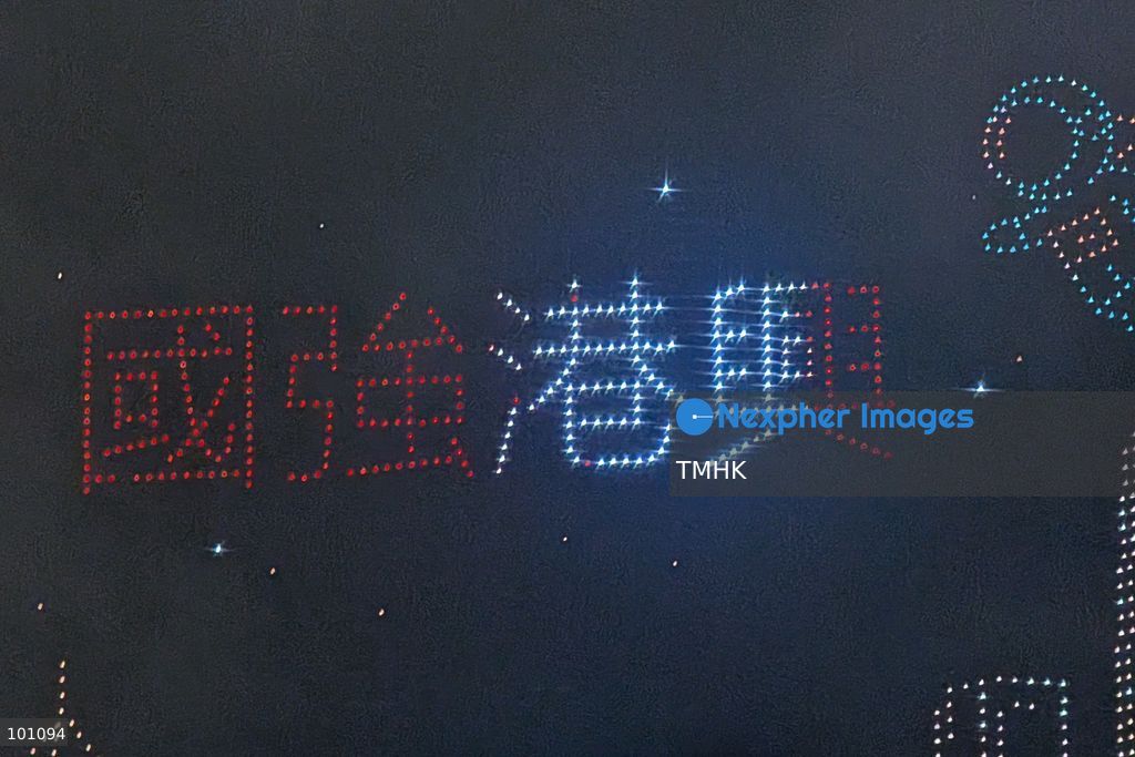 A close-up view captured from the Cross-Harbour Tunnel Bus-Bus Interchange in Hung Hom shows hundreds of illuminated drones forming the Chinese characters for "Strong Nation, Thriving Hong Kong" in the night sky above the Hung Hom waterfront during the 77th National Day drone show on October 2, 2026 in Hong Kong. (Photo by Altman Wong/TMHK via Nexpher Images)