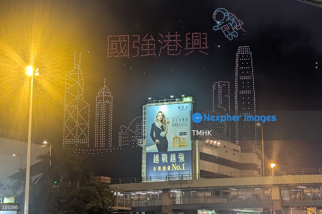 A general wide view captured from the Cross-Harbour Tunnel Bus-Bus Interchange shows drones lighting up the night sky to form the Chinese characters for "Strong Nation, Thriving Hong Kong" above Victoria Harbour and the Hung Hom waterfront during the 77th National Day celebrations on October 2, 2026 in Hong Kong, set against the illuminated harbour backdrop. (Photo by Altman Wong/TMHK via Nexpher Images)