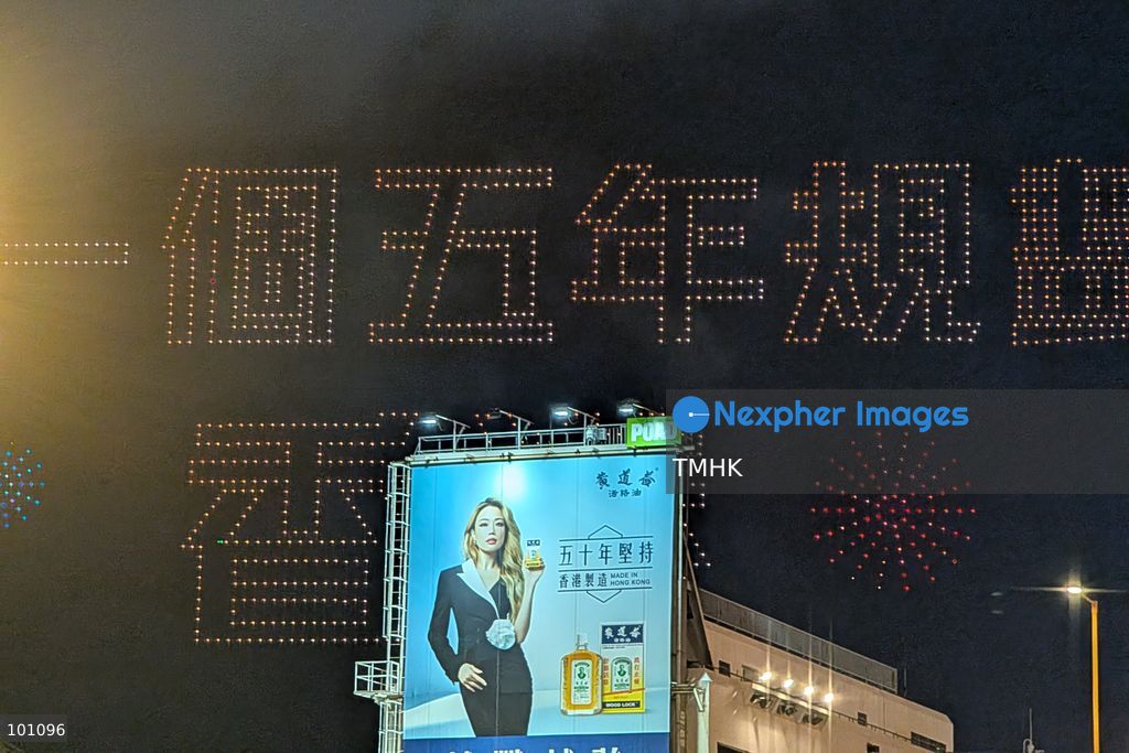 A close-up view captured from the Cross-Harbour Tunnel Bus-Bus Interchange shows illuminated drones assembling to form the Chinese characters for "First Five-Year Plan Hong Kong" above the Hung Hom waterfront on October 2, 2026 in Hong Kong, highlighting the city's strategic development blueprint during the 77th National Day celebrations. (Photo by Altman Wong/TMHK via Nexpher Images)