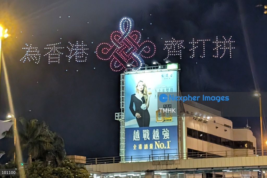 A close-up view captured from the Cross-Harbour Tunnel Bus-Bus Interchange shows hundreds of illuminated drones forming the Chinese characters for "Striving Together for Hong Kong" in the night sky above the Hung Hom waterfront during the 77th National Day drone light show on October 2, 2026 in Hong Kong, rallying community spirit and unity during the celebratory weekend. (Photo by Judy Cheung/TMHK via Nexpher Images)