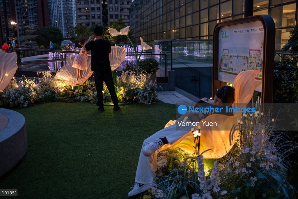 A girl sleeping on a lit flower shaped seat at an outdoor area of a shopping mall on October 3, 2026 in Hong Kong (Photo by Vernon Yuen/Nexpher Images)