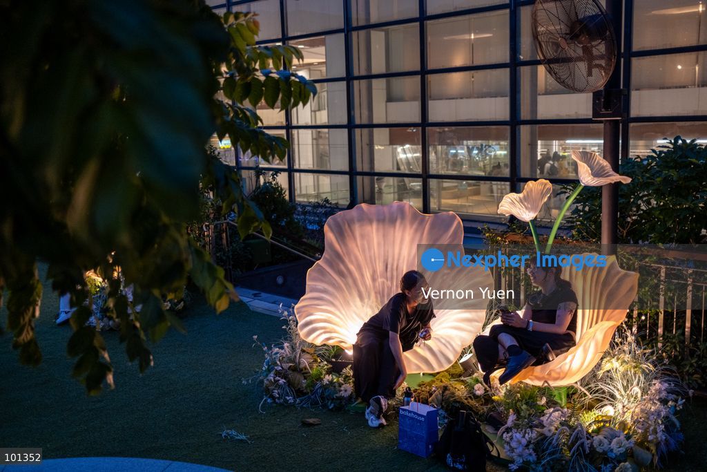 People sitting on a lit flower shaped seat at an outdoor area a shopping mall on October 3, 2026 in Hong Kong (Photo by Vernon Yuen/Nexpher Images)