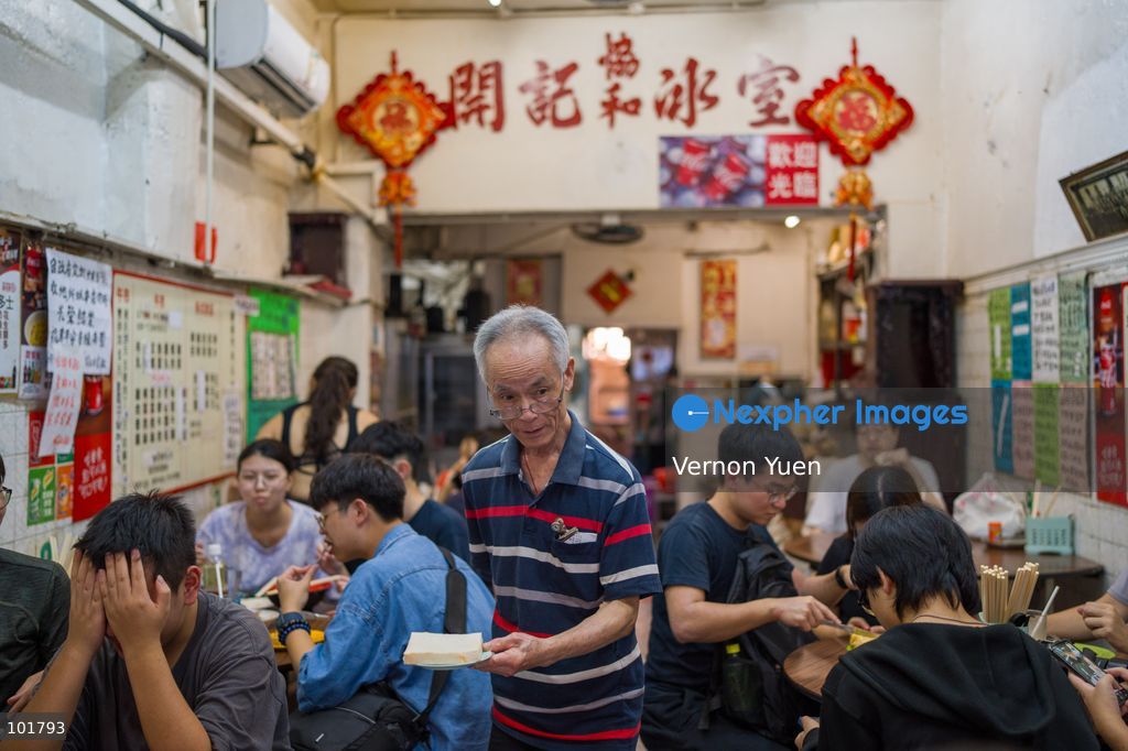 A worker holding a plate of food inside Hoi Kee Cafe at Cha Kwo Ling Village on October 4, 2026 in Hong Kong. Two traditional “Bing Sutt” style restaurants at Cha Kwo Ling Village will shut down after today. (Photo by Vernon Yuen/Nexpher Images)