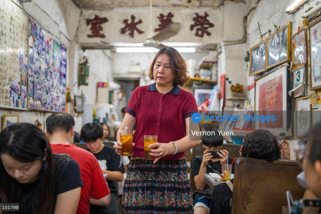 A worker holding two cups of lemon ice teas inside Wing Wah Cafe at Cha Kwo Ling Village on October 4, 2026 in Hong Kong. Two traditional “Bing Sutt” style restaurants at Cha Kwo Ling Village will shut down after today. (Photo by Vernon Yuen/Nexpher Images)