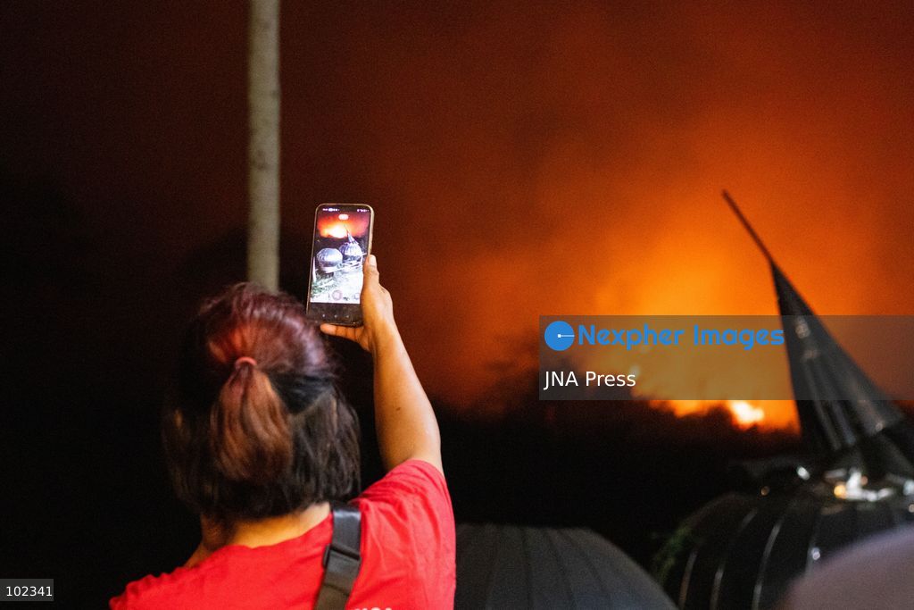 JAMBI, INDONESIA, OCTOBER 6, 2026: Firefighters battle a land fire burning through trees and vegetation in the Penyengat Rendah area of Jambi City, as local residents observe the blaze. Forest and land fires across parts of Jambi and Sumatra continue to affect air quality and raise environmental concerns during the dry season. Photo by Prabanndaru Wahyuaji / JNA Press. (Photo by Prabanndaru Wahyuaji/JNA Press via Nexpher Images)