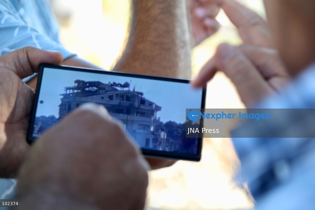 HANNIYEH, SOUTH LEBANON, OCTOBER 6, 2026: Displaced residents of Mansouri watch from the nearby village of Hanniyeh as an Israeli strike hits their home village in southern Lebanon. Residents gather at the vantage point as Israeli attacks and demolitions continue in Mansouri, using mobile phone cameras and zoom lenses to try to identify which homes or buildings have been hit. Mansouri residents have been displaced from the village amid continuing Israeli military operations in the area. Photo by Amanda Flybjerg / JNA PRES (Photo by Amanda Flyvbjerg/JNA Press via Nexpher Images)