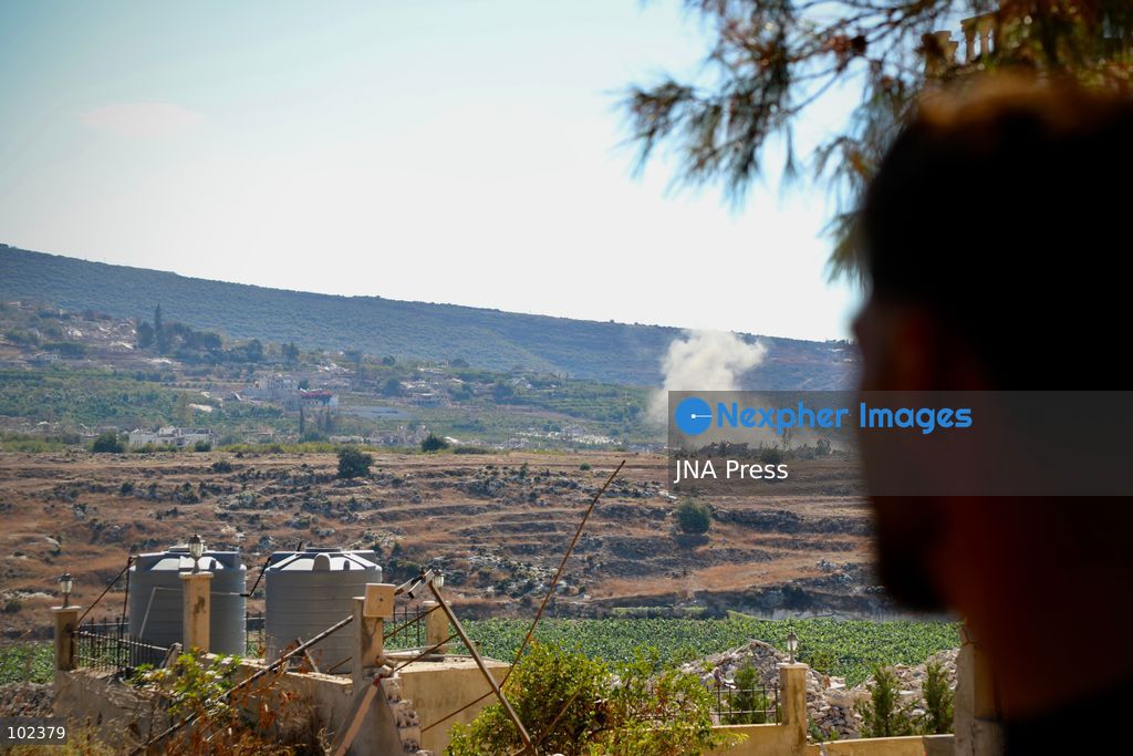 HANNIYEH, SOUTH LEBANON, OCTOBER 6, 2026: Displaced residents of Mansouri watch from the nearby village of Hanniyeh as an Israeli strike hits their home village in southern Lebanon. Residents gather at the vantage point as Israeli attacks and demolitions continue in Mansouri, using mobile phone cameras and zoom lenses to try to identify which homes or buildings have been hit. Mansouri residents have been displaced from the village amid continuing Israeli military operations in the area. Photo by Amanda Flybjerg / JNA PRES (Photo by Amanda Flyvbjerg/JNA Press via Nexpher Images)