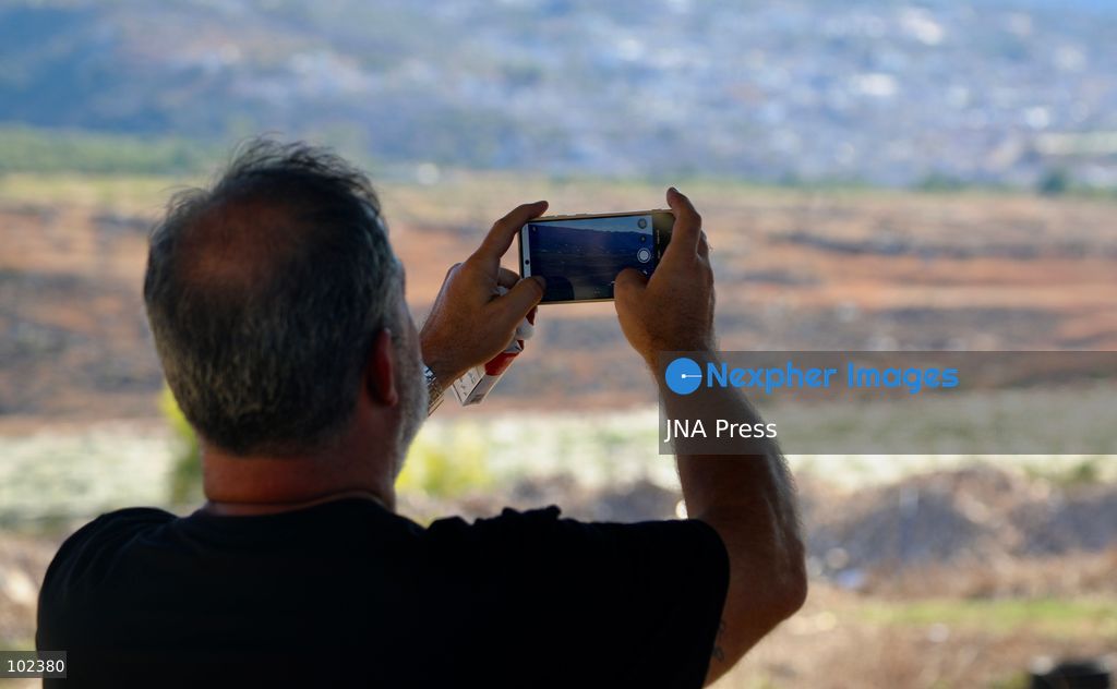 HANNIYEH, SOUTH LEBANON, OCTOBER 6, 2026: Displaced residents of Mansouri watch from the nearby village of Hanniyeh as an Israeli strike hits their home village in southern Lebanon. Residents gather at the vantage point as Israeli attacks and demolitions continue in Mansouri, using mobile phone cameras and zoom lenses to try to identify which homes or buildings have been hit. Mansouri residents have been displaced from the village amid continuing Israeli military operations in the area. Photo by Amanda Flybjerg / JNA PRES (Photo by Amanda Flyvbjerg/JNA Press via Nexpher Images)