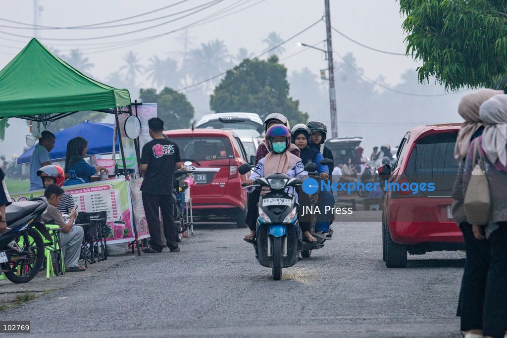 SOLOK, WEST SUMATRA, INDONESIA – OCTOBER 7, 2026: Residents move through Solok, West Sumatra, amid haze linked to widespread forest and land fires on the Indonesian islands of Sumatra and Kalimantan. The fires have contributed to persistent air pollution affecting parts of Indonesia, Malaysia and Singapore. Data from IQAir indicated that the air quality index in West Sumatra reached 189, a level classified as unhealthy and approaching the very unhealthy range. The prolonged haze has affected visibility and raised concerns over air quality and public health across affected areas. The fires are part of recurring seasonal wildfire and land-burning incidents in Indonesia that can produce extensive smoke and transboundary haze. Photo by Wawan Kurniawan / JNA Press. (Photo by Wawan Kurniawan/JNA Press via Nexpher Images)