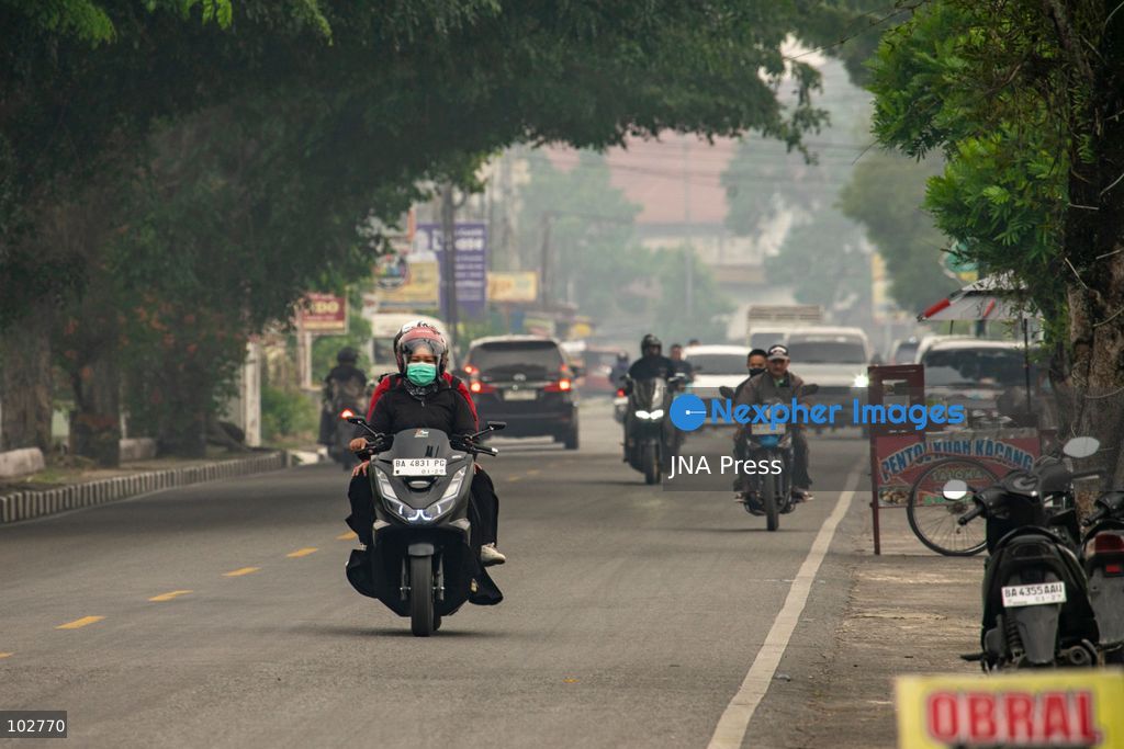 SOLOK, WEST SUMATRA, INDONESIA – OCTOBER 7, 2026: Residents move through Solok, West Sumatra, amid haze linked to widespread forest and land fires on the Indonesian islands of Sumatra and Kalimantan. The fires have contributed to persistent air pollution affecting parts of Indonesia, Malaysia and Singapore. Data from IQAir indicated that the air quality index in West Sumatra reached 189, a level classified as unhealthy and approaching the very unhealthy range. The prolonged haze has affected visibility and raised concerns over air quality and public health across affected areas. The fires are part of recurring seasonal wildfire and land-burning incidents in Indonesia that can produce extensive smoke and transboundary haze. Photo by Wawan Kurniawan / JNA Press. (Photo by Wawan Kurniawan/JNA Press via Nexpher Images)
