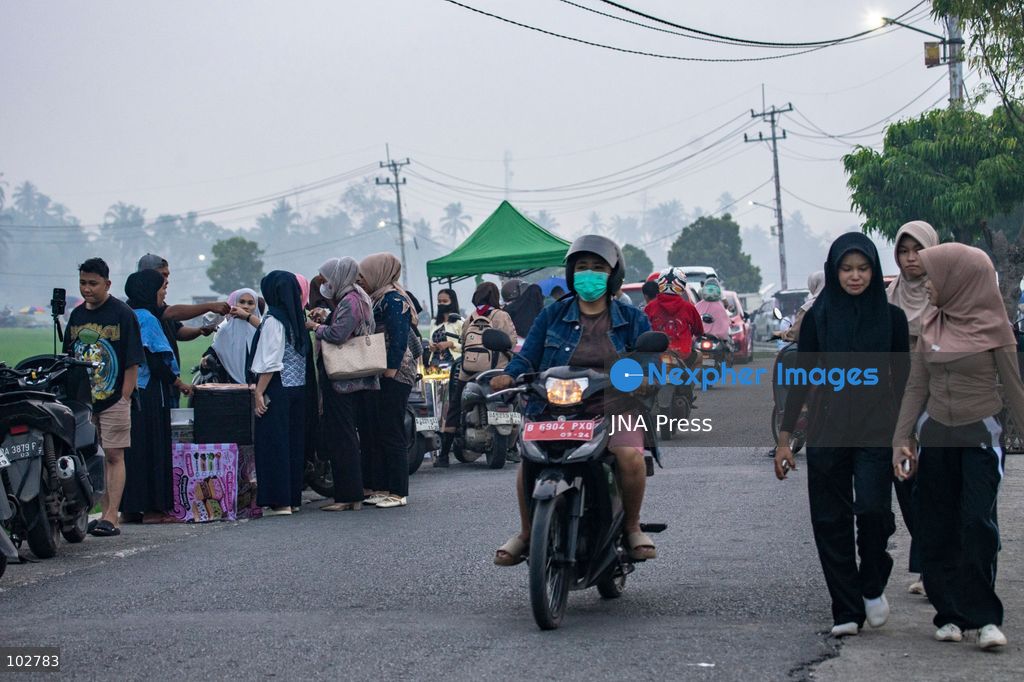 SOLOK, WEST SUMATRA, INDONESIA – OCTOBER 7, 2026: Residents move through Solok, West Sumatra, amid haze linked to widespread forest and land fires on the Indonesian islands of Sumatra and Kalimantan. The fires have contributed to persistent air pollution affecting parts of Indonesia, Malaysia and Singapore. Data from IQAir indicated that the air quality index in West Sumatra reached 189, a level classified as unhealthy and approaching the very unhealthy range. The prolonged haze has affected visibility and raised concerns over air quality and public health across affected areas. The fires are part of recurring seasonal wildfire and land-burning incidents in Indonesia that can produce extensive smoke and transboundary haze. Photo by Wawan Kurniawan / JNA Press. (Photo by Wawan Kurniawan/JNA Press via Nexpher Images)