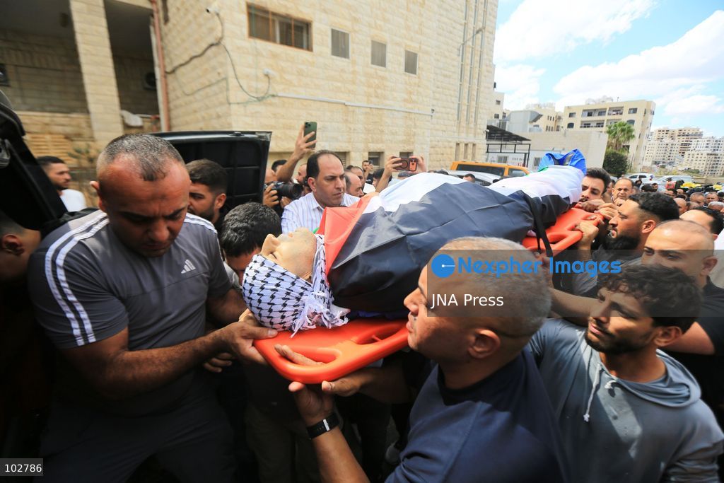 BURQA, NABLUS, PALESTINE – OCTOBER 7, 2026: A large crowd accompanies the body of Ali Hassan Yasser al-Bazari, 44, to his final resting place in the village of Burqa, north of Nablus. The funeral procession departed from Rafidia Hospital and continued to al-Bazari’s home in Burqa, where his family and residents gathered for a final farewell before prayers were held at a local mosque and his body was buried in the village cemetery. Al-Bazari was killed during an attack by Israeli settlers, according to Palestinian authorities, on olive pickers from Burqa in agricultural areas extending between the village and the Ramin Plain east of Tulkarm. He was struck by live ammunition in the lower back and later died from his wounds. The Palestinian Ministry of Health said 16 other people were injured by live ammunition and physical assault during the incident. Photo by Ali Shtayeh / JNA Press. (Photo by ALI Shtayeh/JNA Press via Nexpher Images)