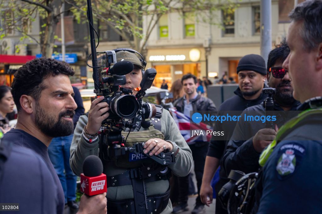MELBOURNE, AUSTRALIA – OCTOBER 7, 2026: A vigil in solidarity with the people of Gaza was held at the State Library of Victoria, with attendees participating in a sit-in from 10:00 AM to 5:00 PM, followed by a commemoration event from 5:00 PM to 6:00 PM to remember those killed. During the event, Avi Yemini of Rebel News Australia arrived with a crew seeking interviews with attendees. Police formed a barricade, while event marshals and police maintained a line to prevent Yemini and his crew from entering the vigil area. According to event organizers, Yemini repeatedly collided with police and attempted to evade the barricade. Photo by Huda Shehzad / JNA Press. (Photo by Huda Shehzad/JNA Press via Nexpher Images)