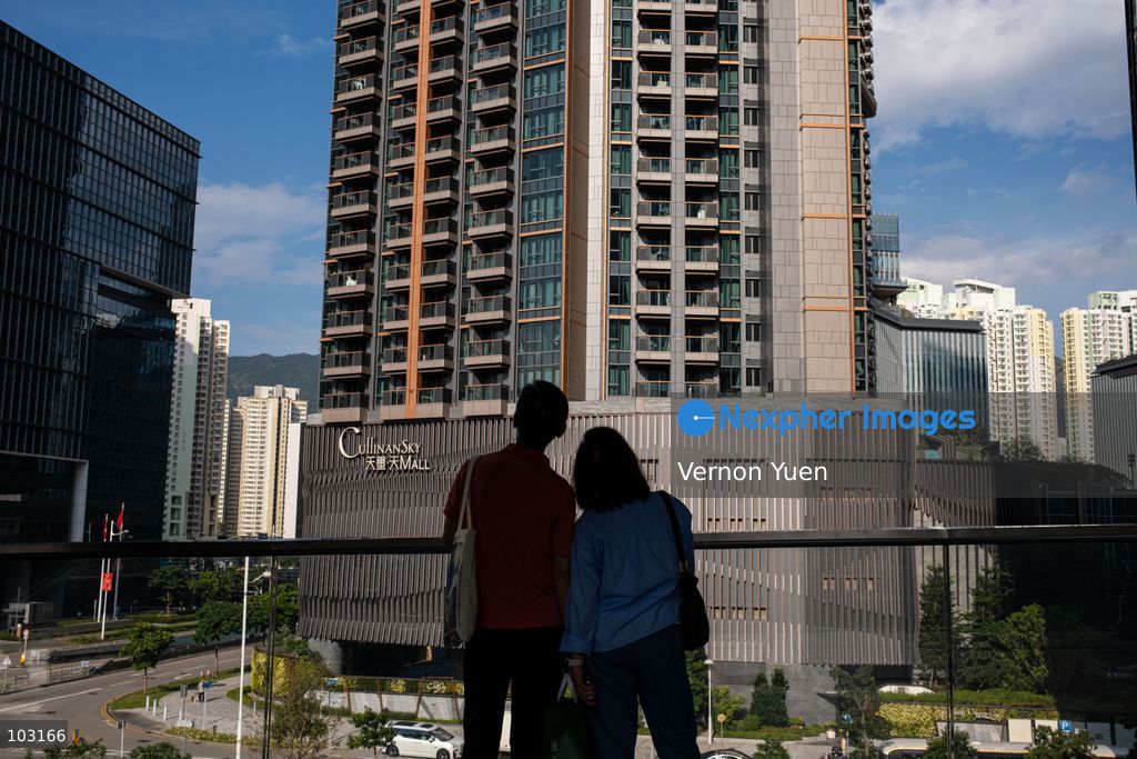 A man and a woman looking at an residential apartment building on October 8, 2026 in Hong Kong. (Photo by Vernon Yuen/Nexpher Images)