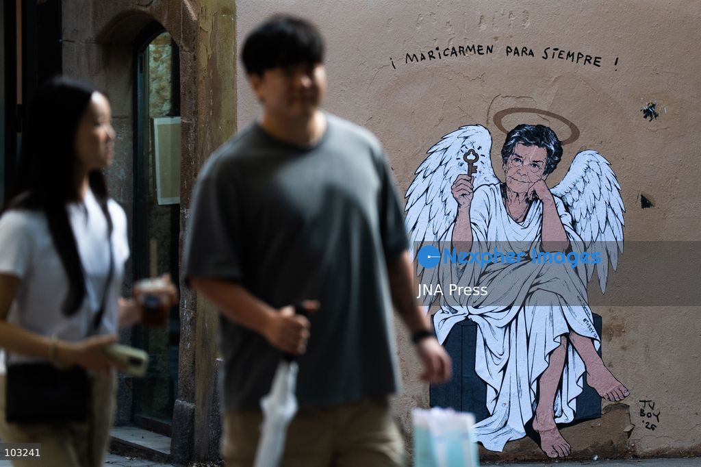 BARCELONA, SPAIN, OCTOBER 8, 2026: Tourists and local residents photograph a mural by urban artist TVBoy depicting Maricarmen Abascal as an angel holding a key in Barcelona. Titled "Maricarmen Para Siempre," the artwork pays tribute to the elderly woman whose eviction and subsequent death sparked widespread housing protests across Spain. Abascal became a symbol of the movement demanding stronger tenant protections and measures against evictions. Photo by Marc Asensio Clupes / JNA Press. (Photo by Marc Asensio Clupes/JNA Press via Nexpher Images)