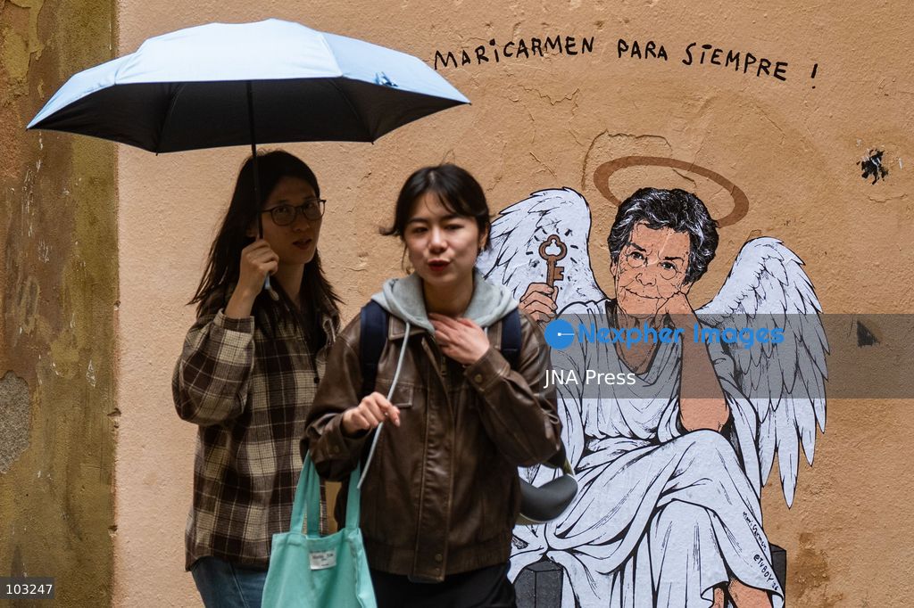 BARCELONA, SPAIN, OCTOBER 8, 2026: Tourists and local residents photograph a mural by urban artist TVBoy depicting Maricarmen Abascal as an angel holding a key in Barcelona. Titled "Maricarmen Para Siempre," the artwork pays tribute to the elderly woman whose eviction and subsequent death sparked widespread housing protests across Spain. Abascal became a symbol of the movement demanding stronger tenant protections and measures against evictions. Photo by Marc Asensio Clupes / JNA Press. (Photo by Marc Asensio Clupes/JNA Press via Nexpher Images)