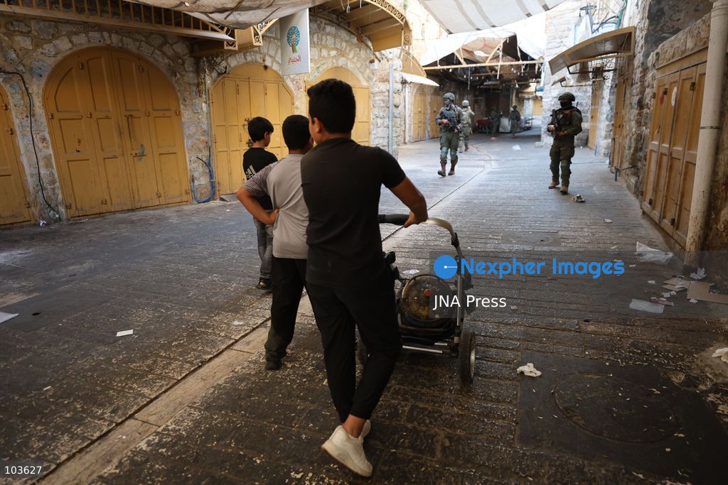 HEBRON, OCCUPIED WEST BANK, OCTOBER 10, 2026: Israeli settlers enter Hebron's Old City under the protection of Israeli forces during an organized visit to the area. Israeli soldiers deployed along streets and around the group as settlers moved through the Old City, where Israeli settlers and Palestinian residents live in close proximity amid longstanding tensions and movement restrictions. Photo by Mosab Shawer / JNA Press. (Photo by Mosab shawer/JNA Press via Nexpher Images)