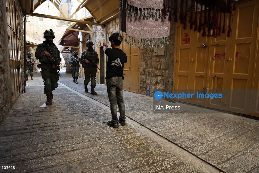 HEBRON, OCCUPIED WEST BANK, OCTOBER 10, 2026: Israeli settlers enter Hebron's Old City under the protection of Israeli forces during an organized visit to the area. Israeli soldiers deployed along streets and around the group as settlers moved through the Old City, where Israeli settlers and Palestinian residents live in close proximity amid longstanding tensions and movement restrictions. Photo by Mosab Shawer / JNA Press. (Photo by Mosab shawer/JNA Press via Nexpher Images)