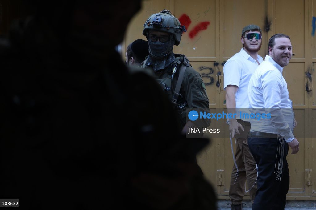 HEBRON, OCCUPIED WEST BANK, OCTOBER 10, 2026: Israeli settlers enter Hebron's Old City under the protection of Israeli forces during an organized visit to the area. Israeli soldiers deployed along streets and around the group as settlers moved through the Old City, where Israeli settlers and Palestinian residents live in close proximity amid longstanding tensions and movement restrictions. Photo by Mosab Shawer / JNA Press. (Photo by Mosab shawer/JNA Press via Nexpher Images)