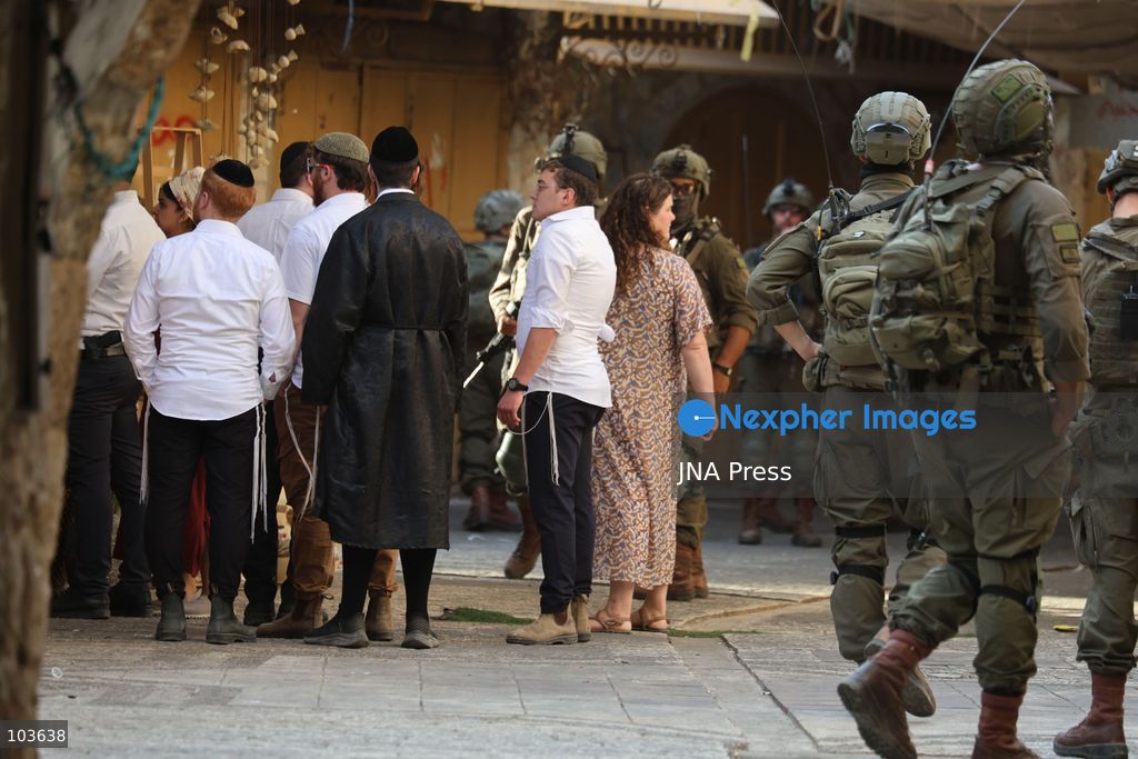 HEBRON, OCCUPIED WEST BANK, OCTOBER 10, 2026: Israeli settlers enter Hebron's Old City under the protection of Israeli forces during an organized visit to the area. Israeli soldiers deployed along streets and around the group as settlers moved through the Old City, where Israeli settlers and Palestinian residents live in close proximity amid longstanding tensions and movement restrictions. Photo by Mosab Shawer / JNA Press. (Photo by Mosab shawer/JNA Press via Nexpher Images)