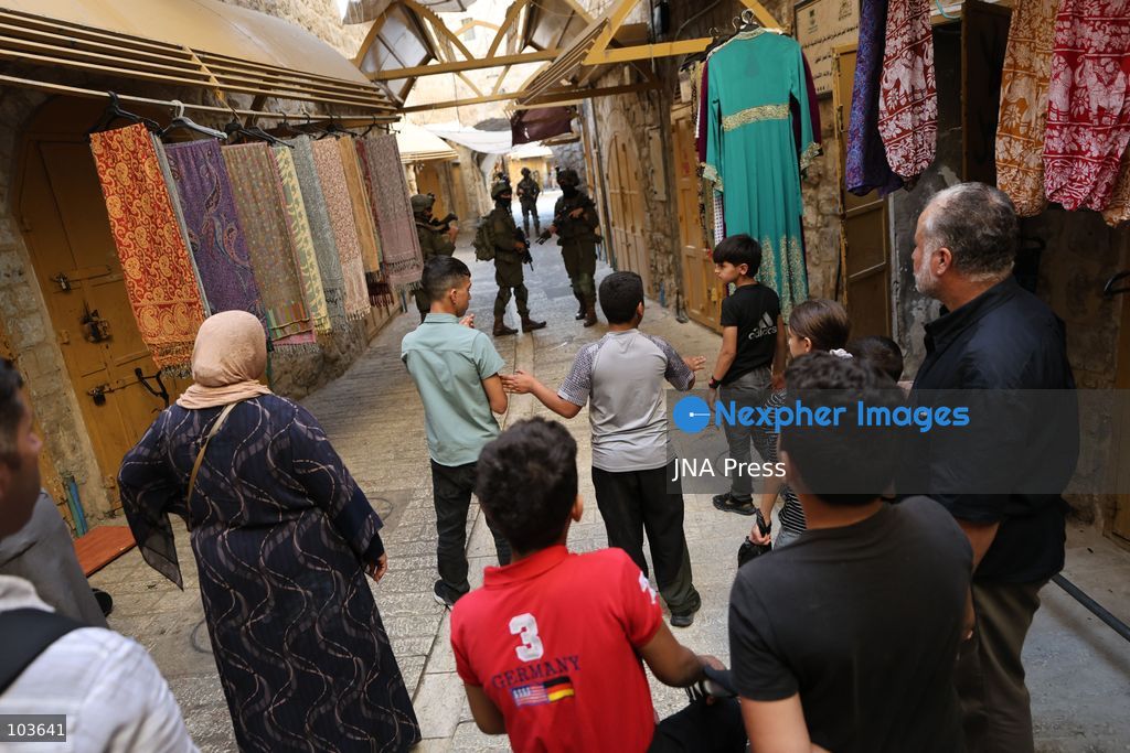 HEBRON, OCCUPIED WEST BANK, OCTOBER 10, 2026: Israeli settlers enter Hebron's Old City under the protection of Israeli forces during an organized visit to the area. Israeli soldiers deployed along streets and around the group as settlers moved through the Old City, where Israeli settlers and Palestinian residents live in close proximity amid longstanding tensions and movement restrictions. Photo by Mosab Shawer / JNA Press. (Photo by Mosab shawer/JNA Press via Nexpher Images)