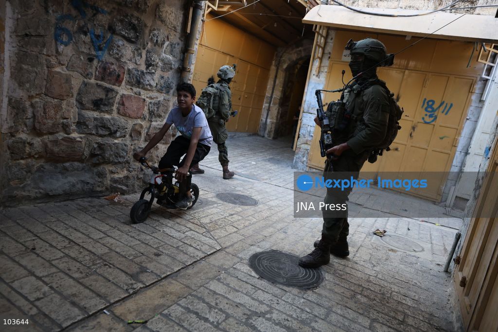 HEBRON, OCCUPIED WEST BANK, OCTOBER 10, 2026: Israeli settlers enter Hebron's Old City under the protection of Israeli forces during an organized visit to the area. Israeli soldiers deployed along streets and around the group as settlers moved through the Old City, where Israeli settlers and Palestinian residents live in close proximity amid longstanding tensions and movement restrictions. Photo by Mosab Shawer / JNA Press. (Photo by Mosab shawer/JNA Press via Nexpher Images)