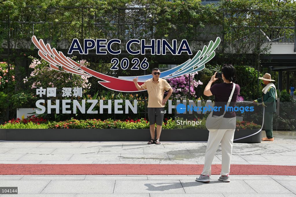 A man posing photo with a decoration of APEC CHINA 2026 at a park on October 11, 2026 in Shenzhen, China. (Photo by Stringer/Nexpher Images)