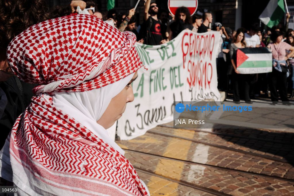 TURIN, ITALY, OCTOBER 10, 2026: A young woman wears a red keffiyeh as she marches alongside other protesters in Piazza Castello, Turin, carrying a banner protesting Israeli policy harming Palestinians. Photo by Luca Prestia / JNA Press (Photo by Luca Prestia/JNA Press via Nexpher Images)