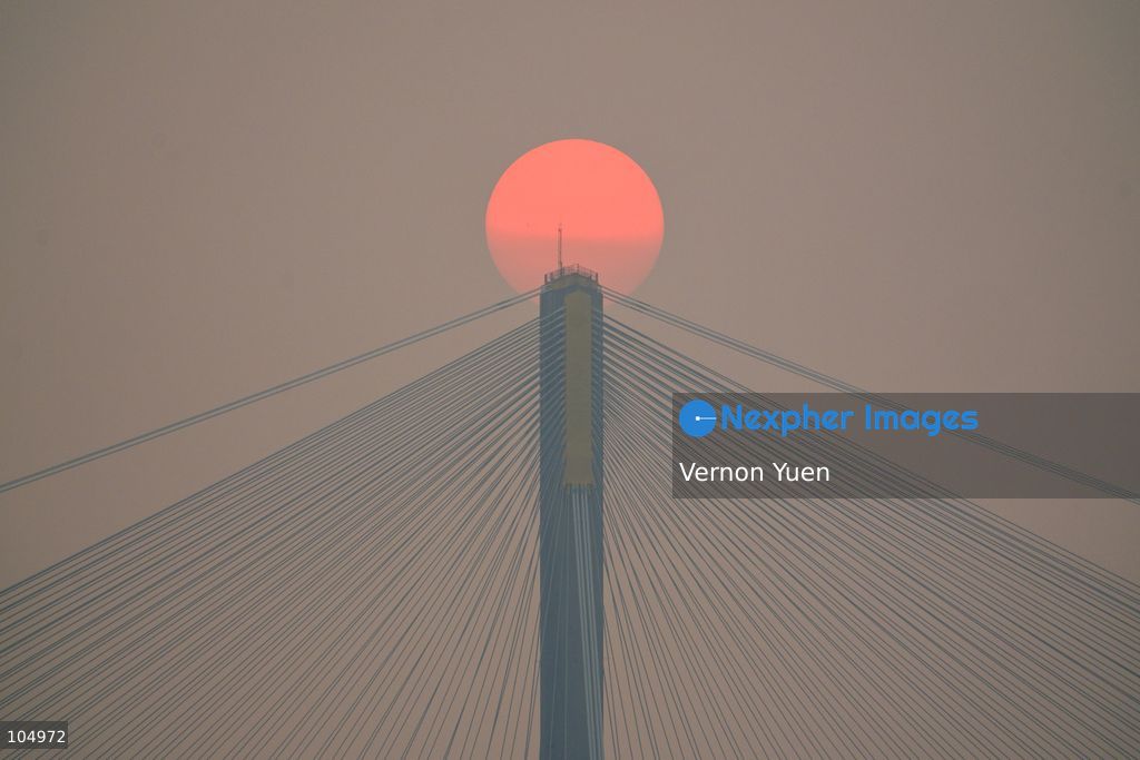 A general view showing the sun behind a bridge during sunset on October 13, 2026 in Hong Kong. (Photo by Vernon Yuen/Nexpher Images)