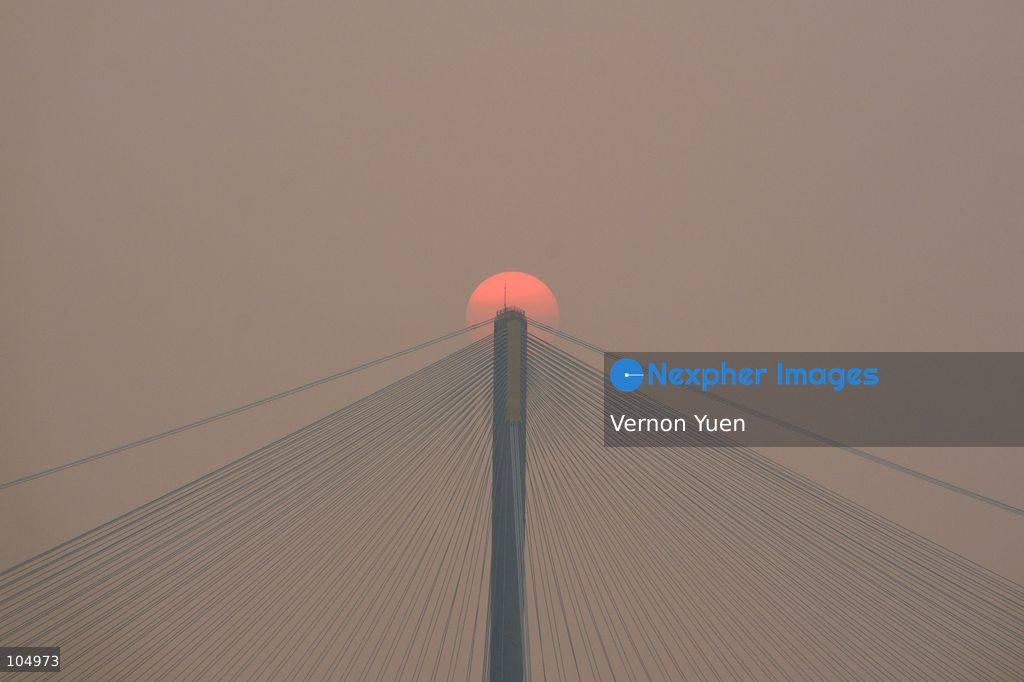 A general view showing the sun behind a bridge during sunset on October 13, 2026 in Hong Kong. (Photo by Vernon Yuen/Nexpher Images)