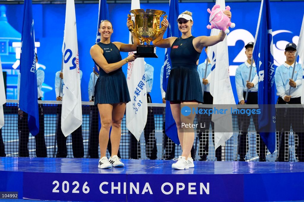 Gabriela Dabrowski of Canada and Luisa Stefani of Brazil pose with the trophy after winning against Zhang Shuai of China and Katerina Siniakova of the Czech Republic 2-0 in the women's doubles final at the Diamond Court of the National Tennis Center in Beijing, China, on October 11, 2026. Stefani (R) and Dabrowski are seen discussing their serving tactics. (Photo by Peter Li/Nexpher Images)