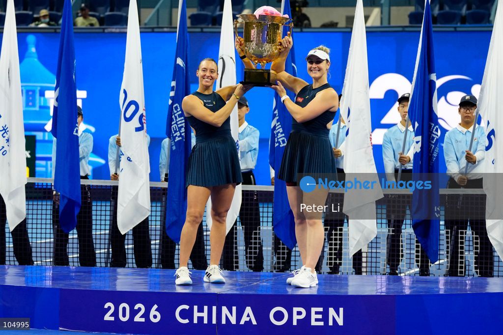 Gabriela Dabrowski of Canada and Luisa Stefani of Brazil pose with the trophy after winning against Zhang Shuai of China and Katerina Siniakova of the Czech Republic 2-0 in the women's doubles final at the Diamond Court of the National Tennis Center in Beijing, China, on October 11, 2026. Stefani (R) and Dabrowski are seen discussing their serving tactics. (Photo by Peter Li/Nexpher Images)