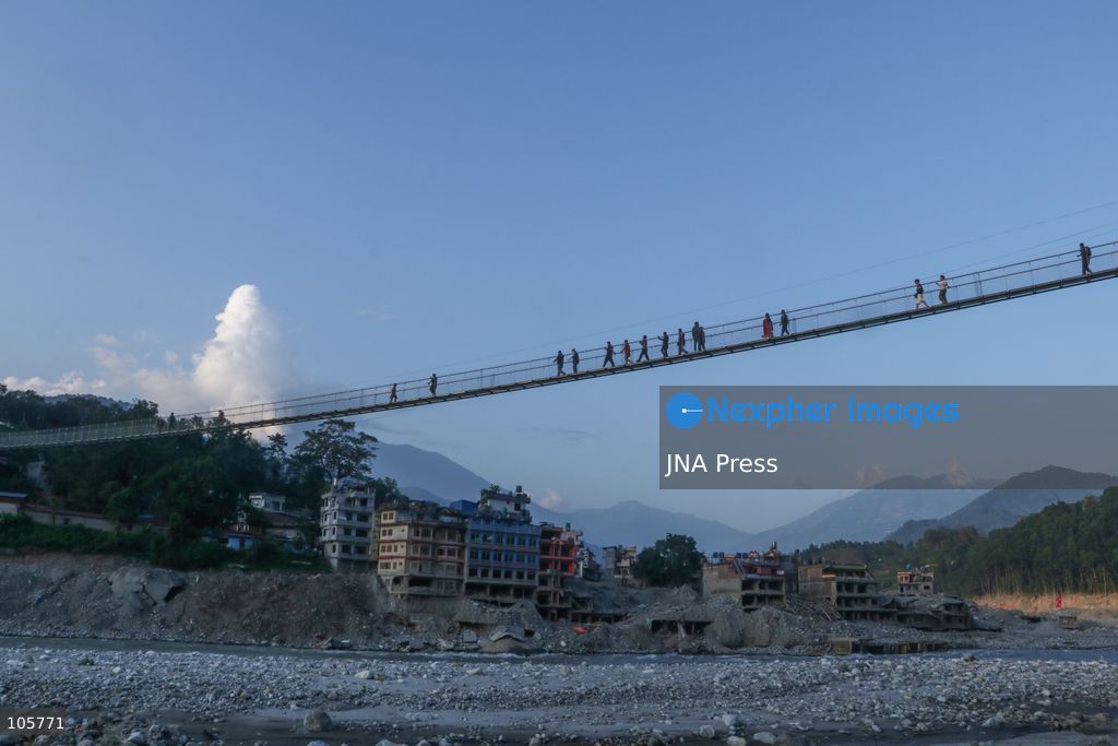 NUWAKOT, NEPAL, OCTOBER 14, 2026: Residents cross a newly built suspension bridge over the Trishuli River in Nuwakot, restoring access between communities affected by flash floods. Flooding destroyed bridges and damaged roads in the district, disrupting travel and access to essential services. Photo by Shankar Bhujel / JNA Press (Photo by Shankar Bhujel/JNA Press via Nexpher Images)