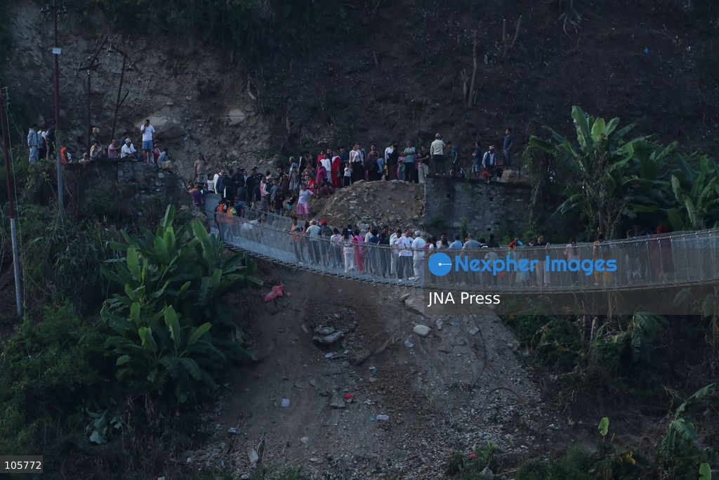 NUWAKOT, NEPAL, OCTOBER 14, 2026: Residents cross a newly built suspension bridge over the Trishuli River in Nuwakot, restoring access between communities affected by flash floods. Flooding destroyed bridges and damaged roads in the district, disrupting travel and access to essential services. Photo by Shankar Bhujel / JNA Press (Photo by Shankar Bhujel/JNA Press via Nexpher Images)