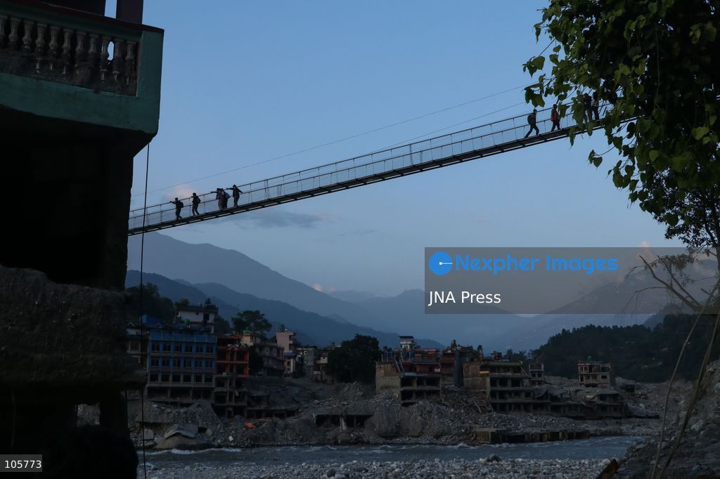 NUWAKOT, NEPAL, OCTOBER 14, 2026: Residents cross a newly built suspension bridge over the Trishuli River in Nuwakot, restoring access between communities affected by flash floods. Flooding destroyed bridges and damaged roads in the district, disrupting travel and access to essential services. Photo by Shankar Bhujel / JNA Press (Photo by Shankar Bhujel/JNA Press via Nexpher Images)
