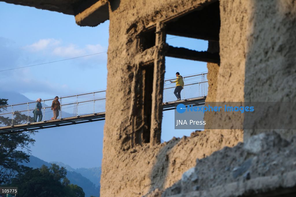 NUWAKOT, NEPAL, OCTOBER 14, 2026: Residents cross a newly built suspension bridge over the Trishuli River in Nuwakot, restoring access between communities affected by flash floods. Flooding destroyed bridges and damaged roads in the district, disrupting travel and access to essential services. Photo by Shankar Bhujel / JNA Press (Photo by Shankar Bhujel/JNA Press via Nexpher Images)