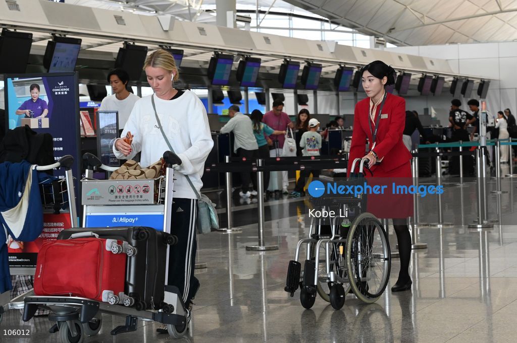 A Cathay Pacific Flight Attendant pushing a wheelchair at Hong Kong Information Airport on October 15, 2026 in Hong Kong.