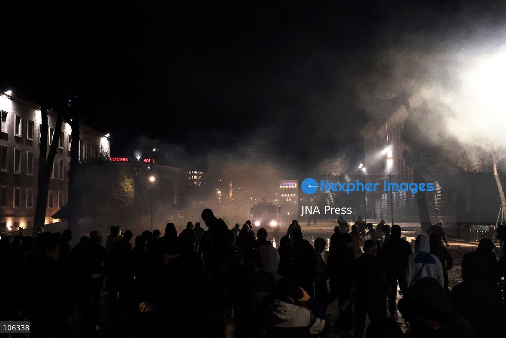 TIRANA, ALBANIA, OCTOBER 15, 2026: Students and other demonstrators protest near the Prime Minister’s Office in Tirana on the third consecutive day of anti-government demonstrations, demanding better university conditions and the resignation of Prime Minister Edi Rama. Clashes erupt between protesters and riot police, with demonstrators throwing stones, metal objects and pyrotechnics while officers respond with tear gas and water cannons. Fires are set in rubbish bins and at street kiosks, and damaged public property and debris are scattered across central Tirana. Some demonstrators are detained, while others help protesters affected by tear gas by pouring water over their faces to rinse their eyes. A bloodied female demonstrator is held on the ground by other protesters amid the confrontations. Photo by Vlasov Sulaj / JNA Press (Photo by Vlasov Sulaj/JNA Press via Nexpher Images)