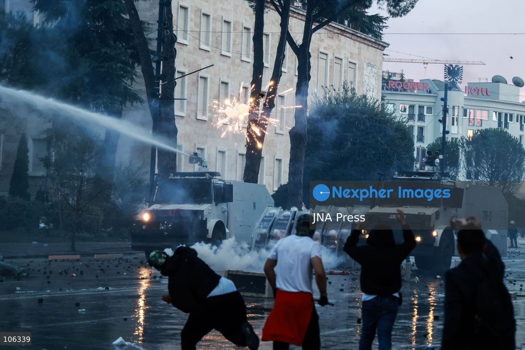 TIRANA, ALBANIA, OCTOBER 15, 2026: Students and other demonstrators protest near the Prime Minister’s Office in Tirana on the third consecutive day of anti-government demonstrations, demanding better university conditions and the resignation of Prime Minister Edi Rama. Clashes erupt between protesters and riot police, with demonstrators throwing stones, metal objects and pyrotechnics while officers respond with tear gas and water cannons. Fires are set in rubbish bins and at street kiosks, and damaged public property and debris are scattered across central Tirana. Some demonstrators are detained, while others help protesters affected by tear gas by pouring water over their faces to rinse their eyes. A bloodied female demonstrator is held on the ground by other protesters amid the confrontations. Photo by Vlasov Sulaj / JNA Press (Photo by Vlasov Sulaj/JNA Press via Nexpher Images)