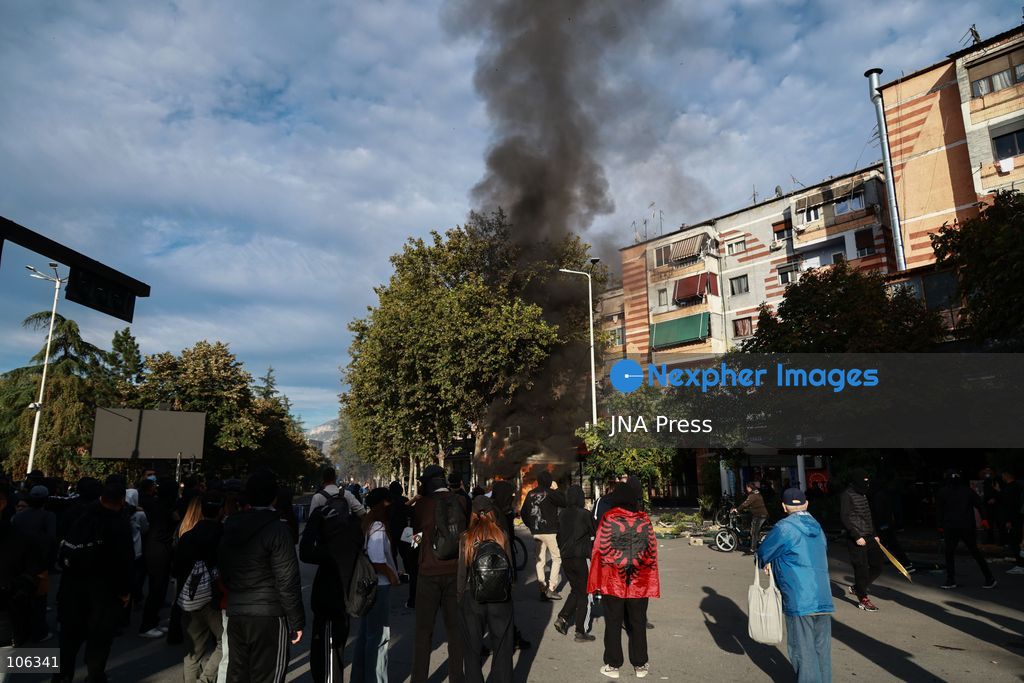 TIRANA, ALBANIA, OCTOBER 15, 2026: Students and other demonstrators protest near the Prime Minister’s Office in Tirana on the third consecutive day of anti-government demonstrations, demanding better university conditions and the resignation of Prime Minister Edi Rama. Clashes erupt between protesters and riot police, with demonstrators throwing stones, metal objects and pyrotechnics while officers respond with tear gas and water cannons. Fires are set in rubbish bins and at street kiosks, and damaged public property and debris are scattered across central Tirana. Some demonstrators are detained, while others help protesters affected by tear gas by pouring water over their faces to rinse their eyes. A bloodied female demonstrator is held on the ground by other protesters amid the confrontations. Photo by Vlasov Sulaj / JNA Press (Photo by Vlasov Sulaj/JNA Press via Nexpher Images)