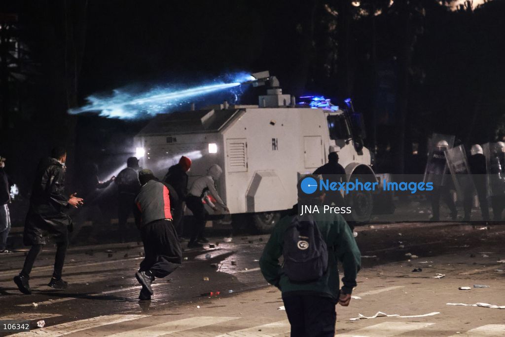 TIRANA, ALBANIA, OCTOBER 15, 2026: Students and other demonstrators protest near the Prime Minister’s Office in Tirana on the third consecutive day of anti-government demonstrations, demanding better university conditions and the resignation of Prime Minister Edi Rama. Clashes erupt between protesters and riot police, with demonstrators throwing stones, metal objects and pyrotechnics while officers respond with tear gas and water cannons. Fires are set in rubbish bins and at street kiosks, and damaged public property and debris are scattered across central Tirana. Some demonstrators are detained, while others help protesters affected by tear gas by pouring water over their faces to rinse their eyes. A bloodied female demonstrator is held on the ground by other protesters amid the confrontations. Photo by Vlasov Sulaj / JNA Press (Photo by Vlasov Sulaj/JNA Press via Nexpher Images)